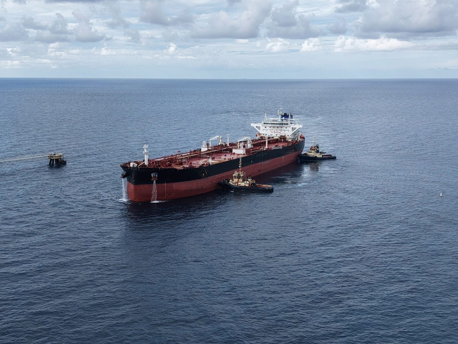 A laden tanker is manoeuvred by two tugs off the Liwathon B.O.S. Sea Island, Grand Bahama.