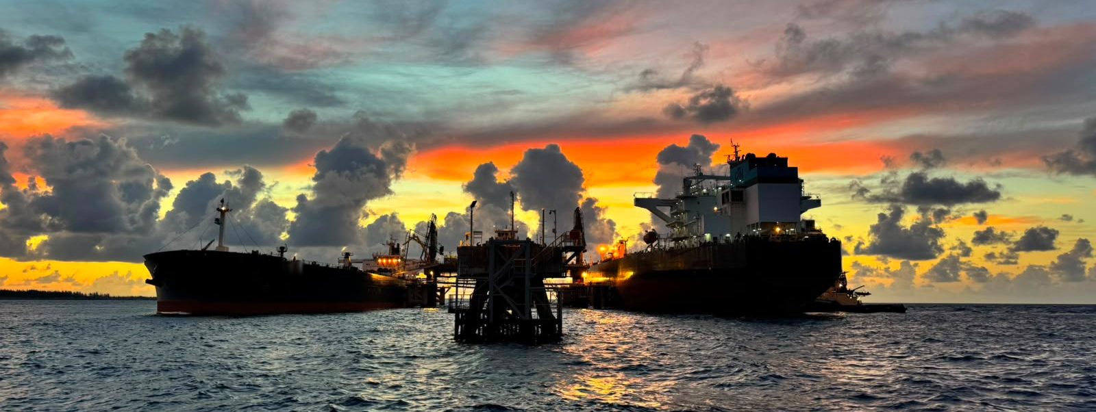 Two tankers berthed either side of the Liwathon B.O.S. Sea Island at sunset, off Grand Bahama.