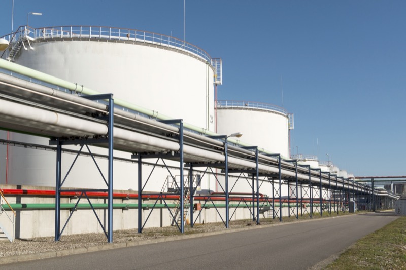A pipe rack runs along a row of storage tanks at Liwathon E.O.S.