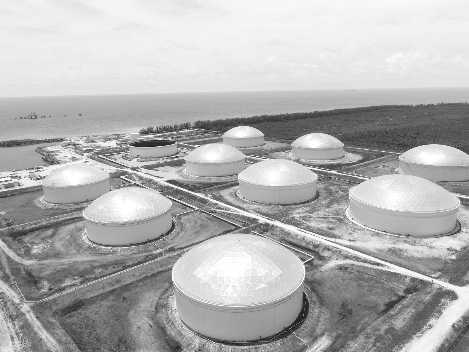 Domed storage tanks of Liwathon B.O.S. at South Riding Point, Grand Bahama, seen from the air, with the Sea Island offshore.